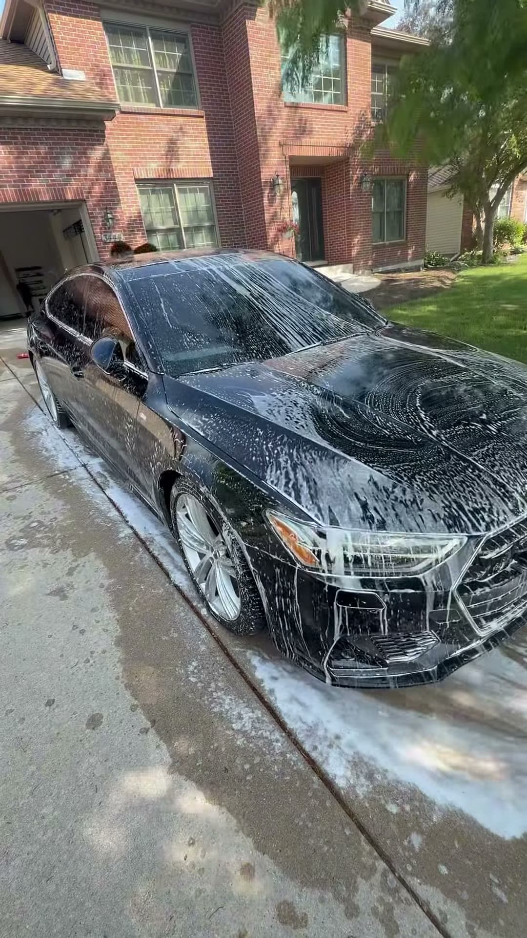 Black Audi covered in foam during an exterior wash