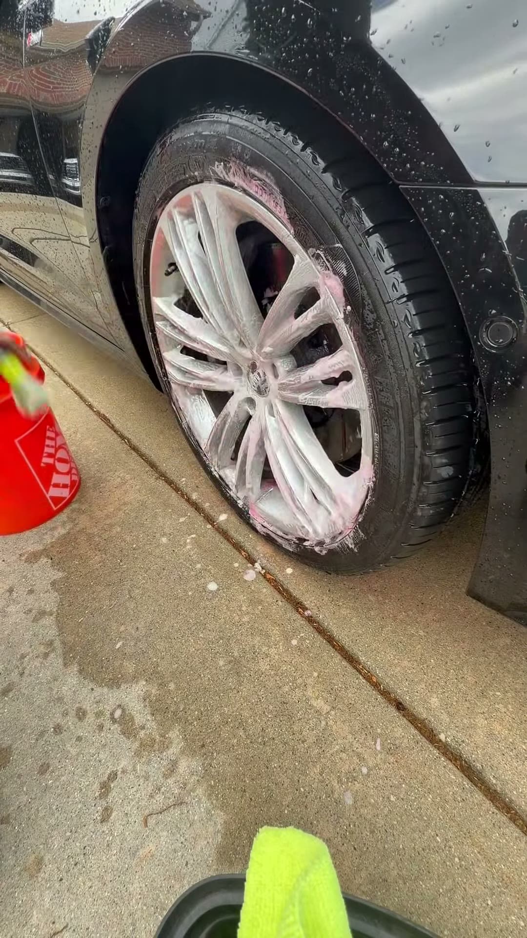 Wheel cleaner being worked across a black Audi wheel