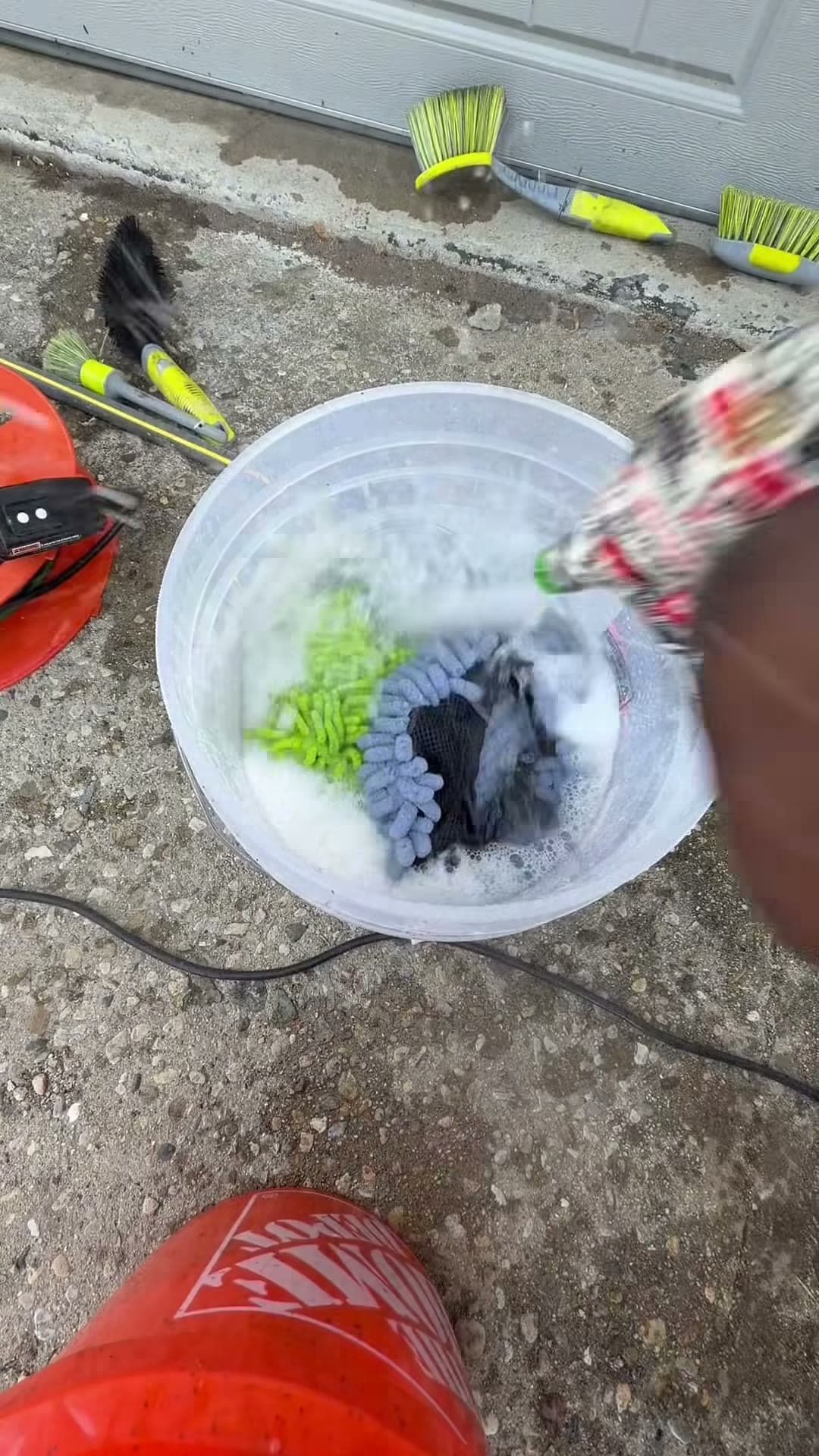 Detailing brushes being rinsed beside wash buckets