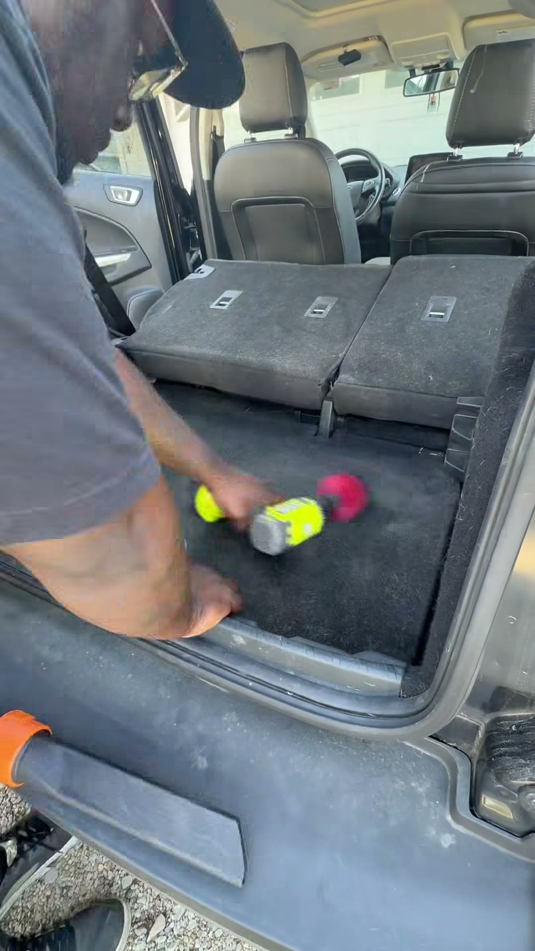 Detailer brushing the Ford Explorer cargo carpet