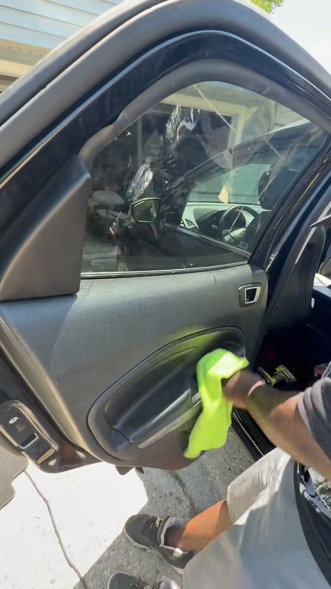 Detailer cleaning the inside window of a Ford Explorer