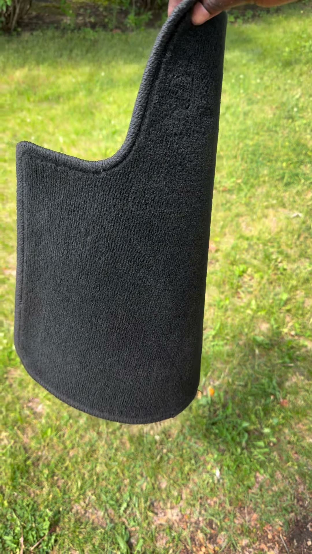 Clean vehicle floor mat held up after the focused cleaning sequence